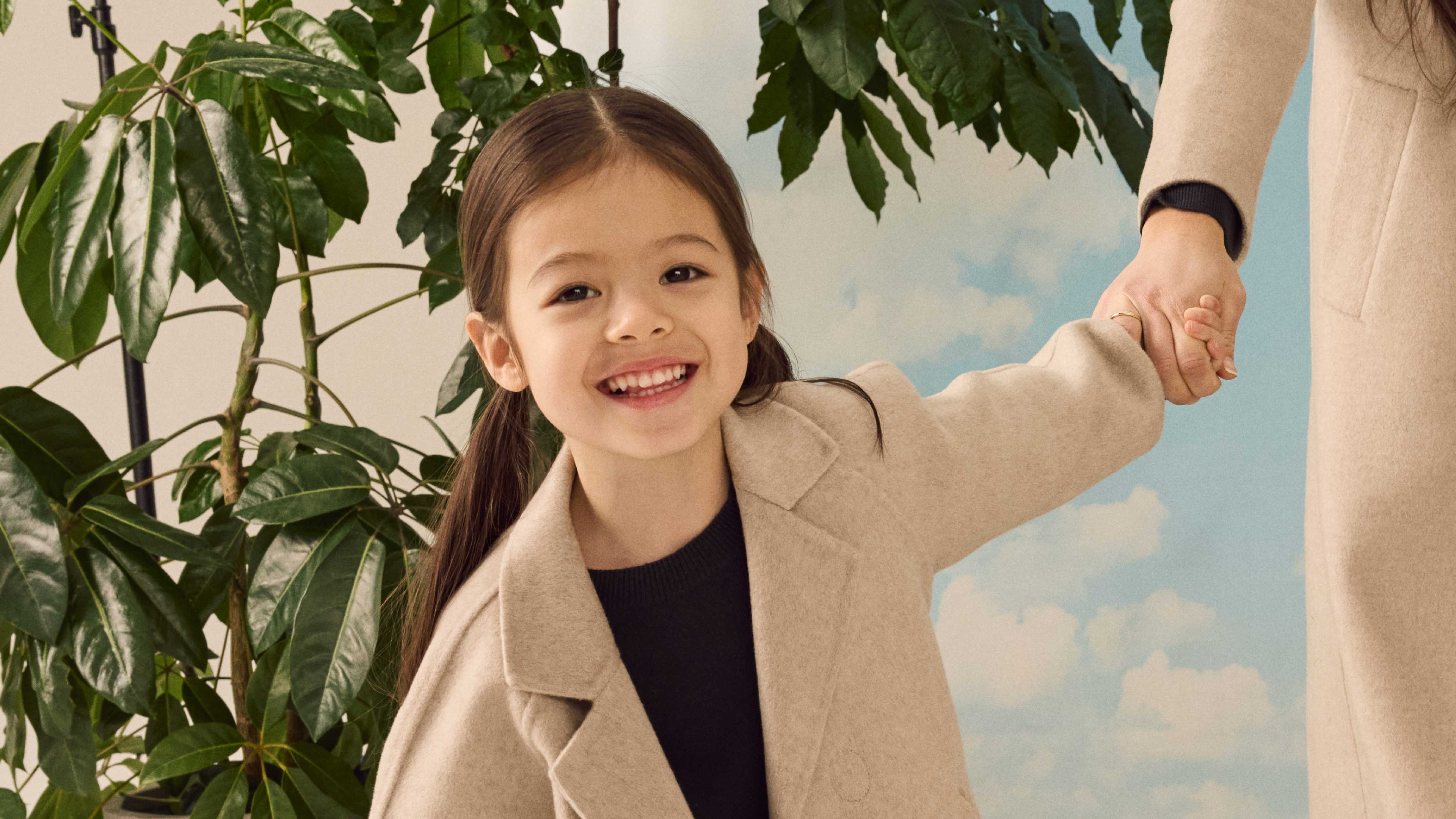  A young girl smiling wearing the Nuna Cashmere Coat in Beige