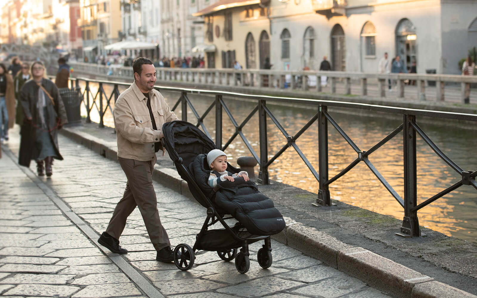 A father pushes his son in the TRIV lx pushchair with winter seat cover.