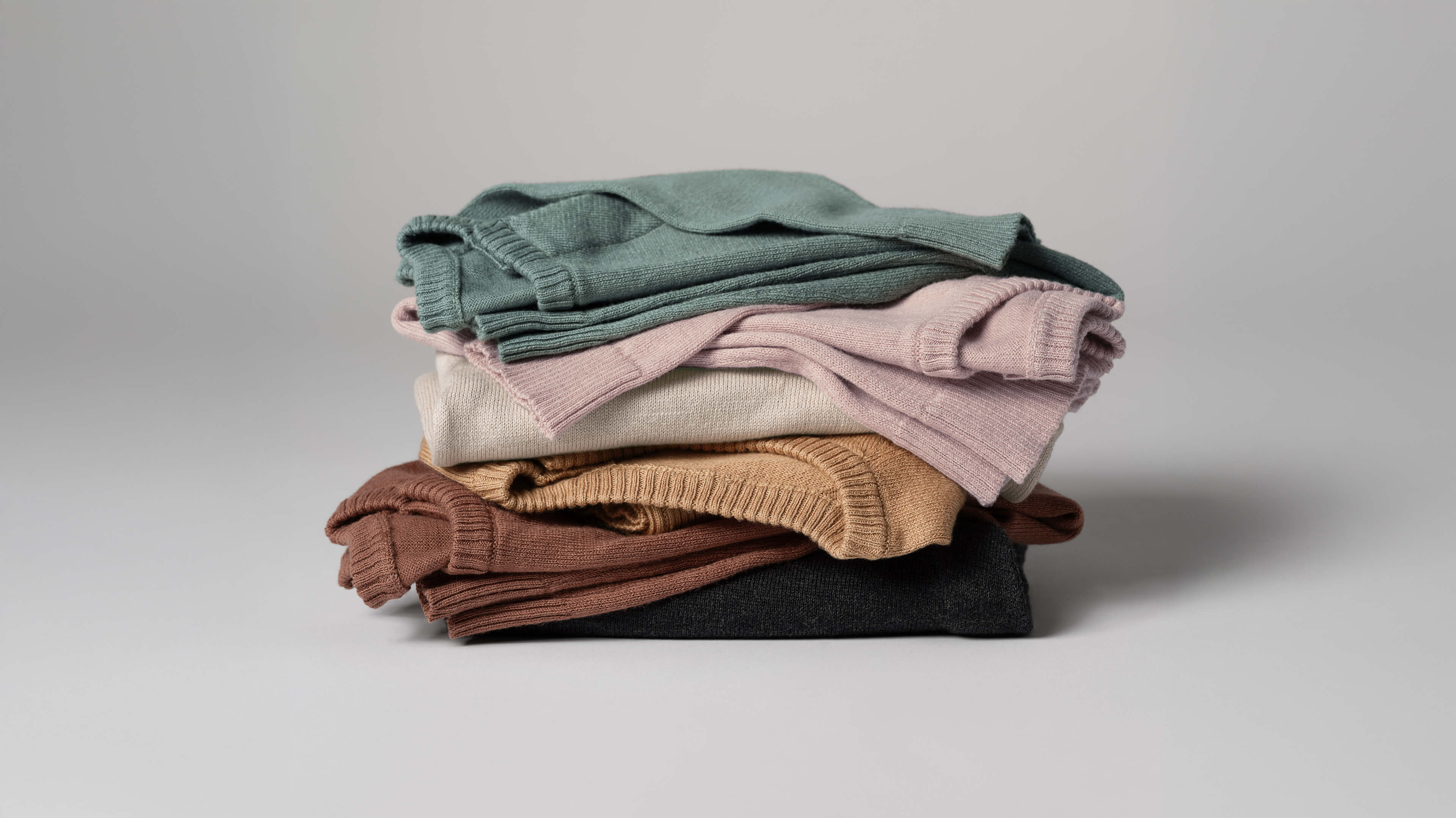 Six Nuna Cotton Onesies, one in each fashion stacked on top of each other