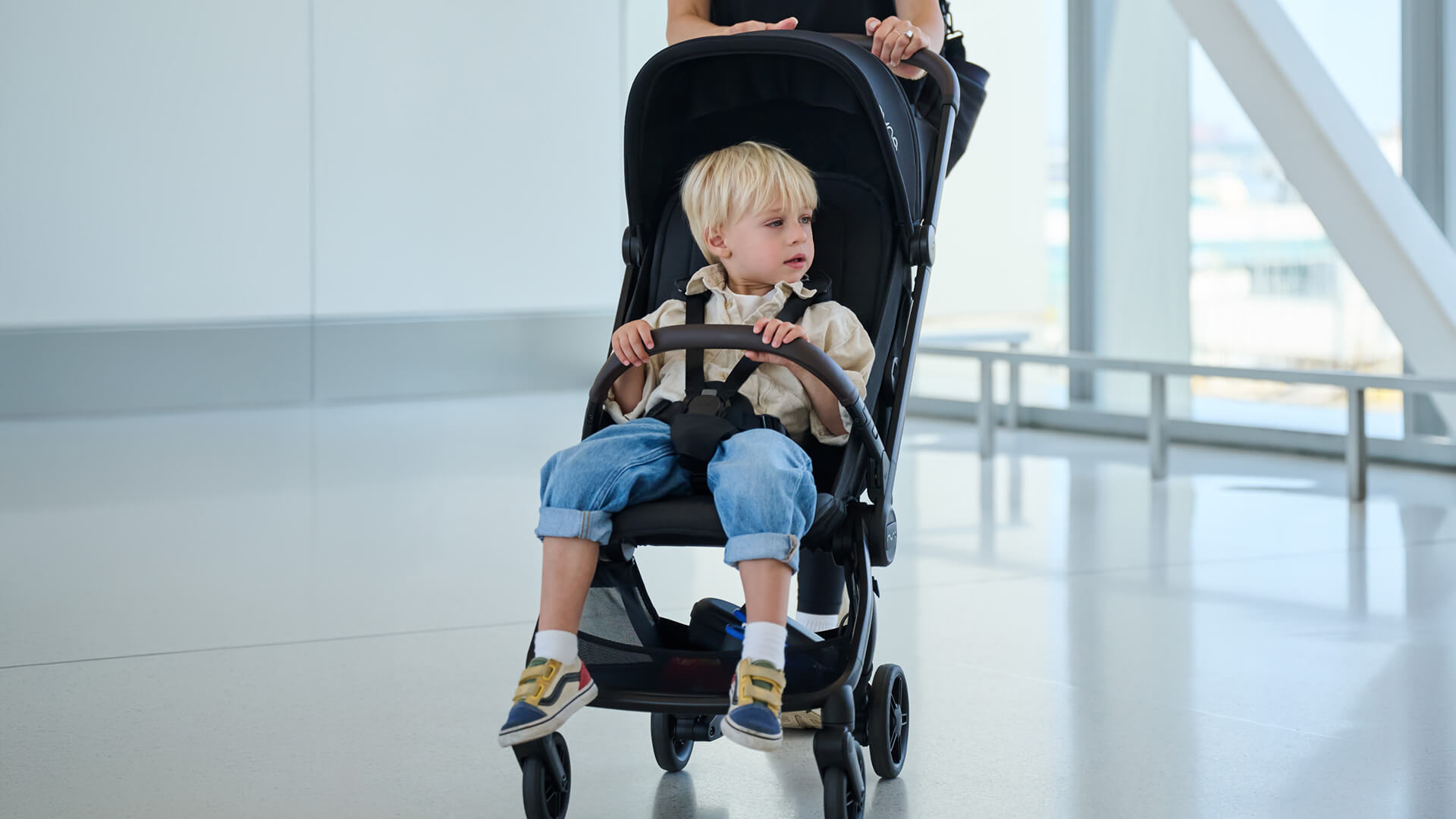 A young boy rides through the airport in the VIAA cabn pushchair.