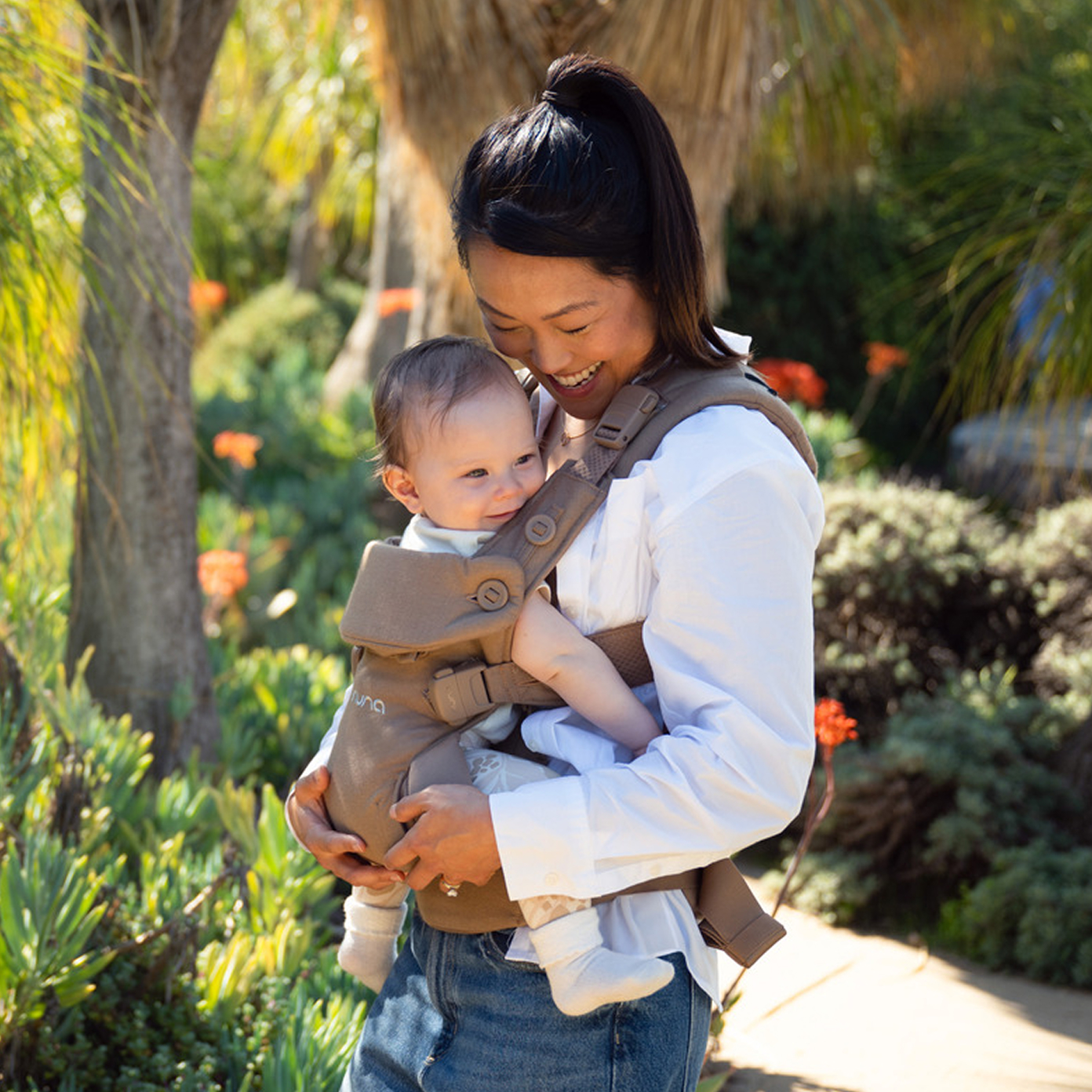 A mother wearing her baby in the Nuna CUDL Series infant carrier.
